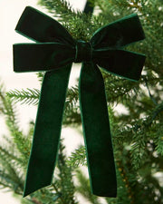 Sage green 16.5 cm velvet double bow with long tails attached to a Christmas tree branch.