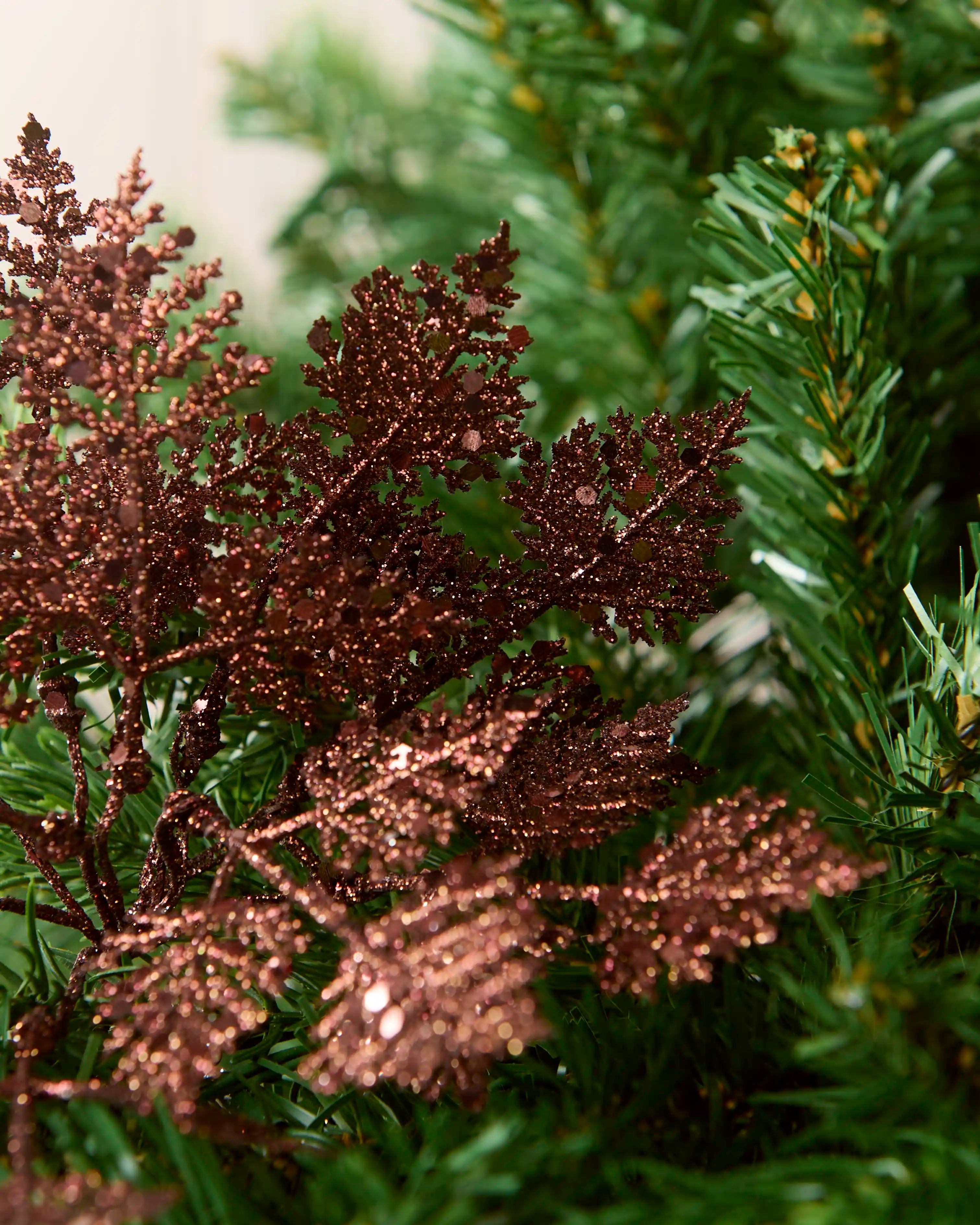 Detailed close-up of espresso glitter leaf picks with textured foliage and reflective glitter pieces.