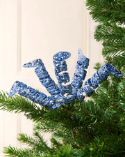 Set of three 18 cm ice blue glitter spiral picks arranged among green Christmas tree branches.