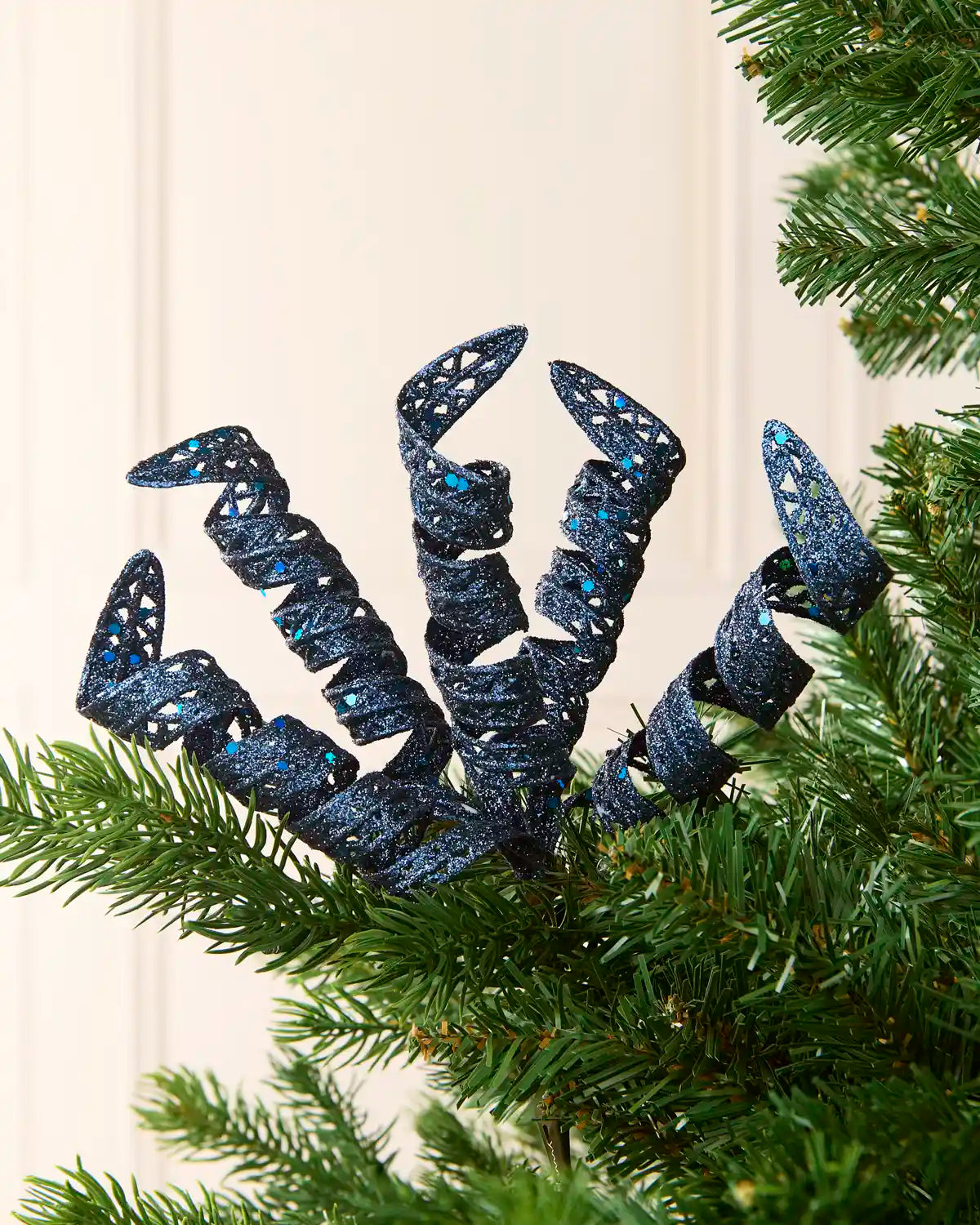 Set of three 18 cm navy glitter spiral picks arranged among green Christmas tree branches.