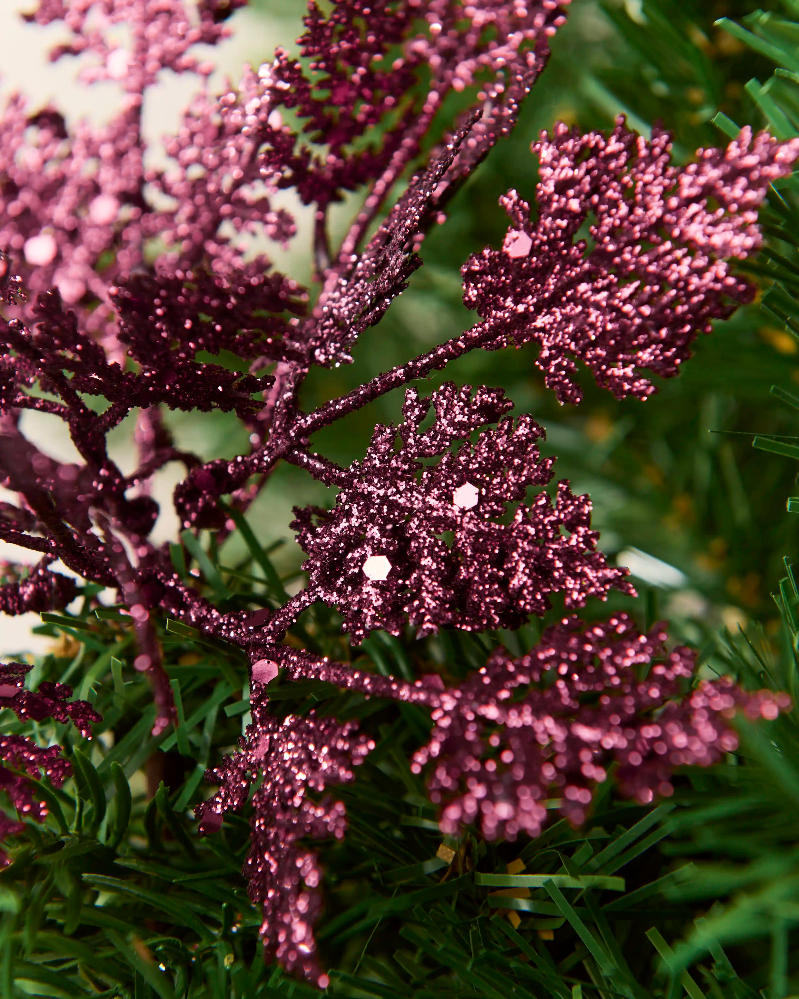 Detailed close-up of purple glitter leaf picks with textured foliage and reflective glitter pieces.