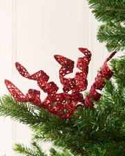 Set of three 18 cm red glitter spiral picks arranged among green Christmas tree branches.