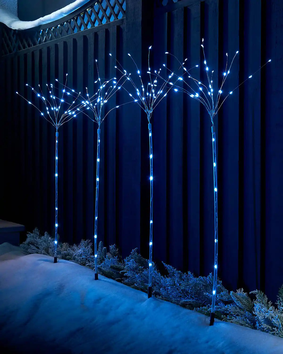 Set of 4 firework pathway stake lights illuminated in a garden display