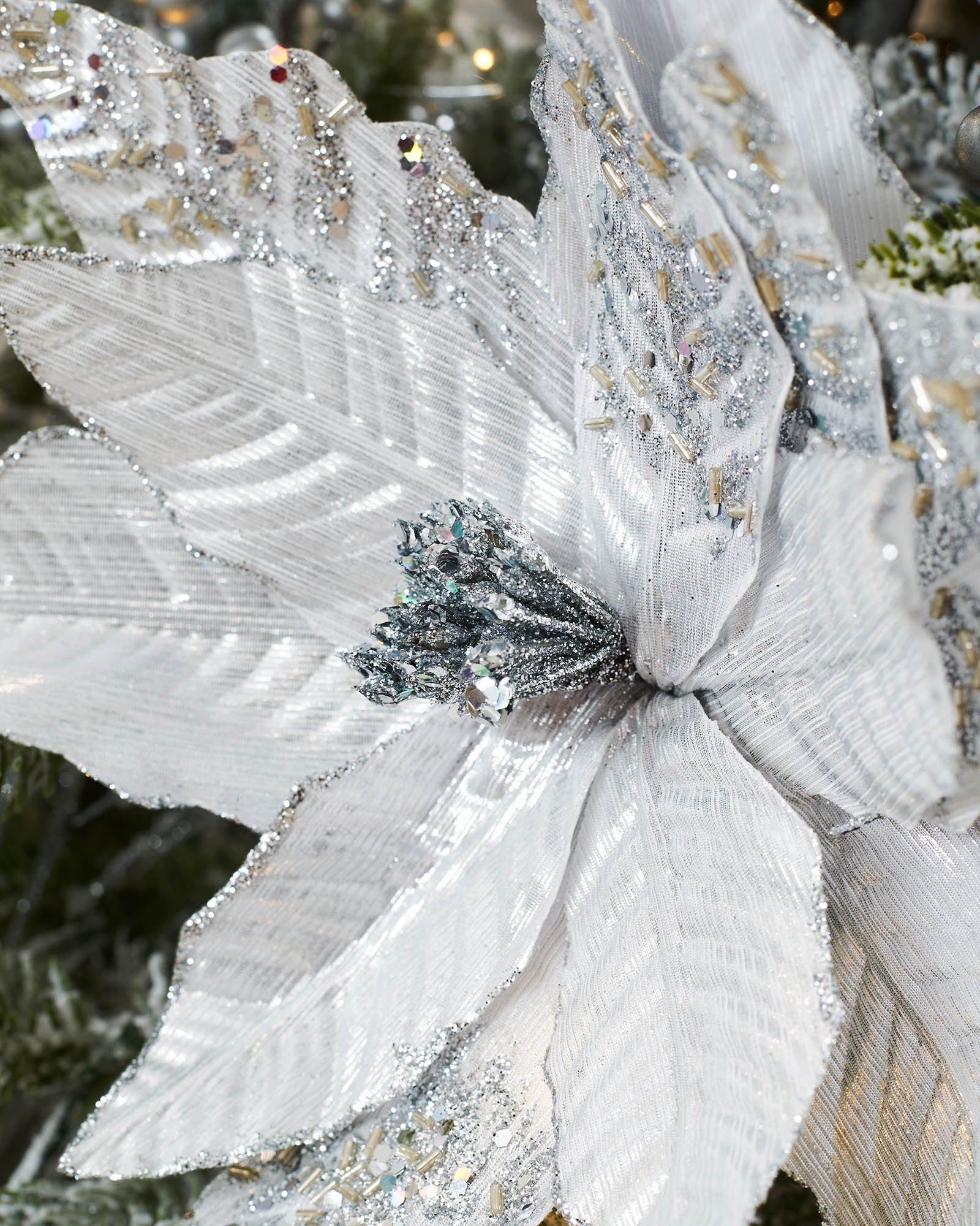 Close-up of a 30 cm silver artificial poinsettia flower showing glittered petals and decorative silver stigma.