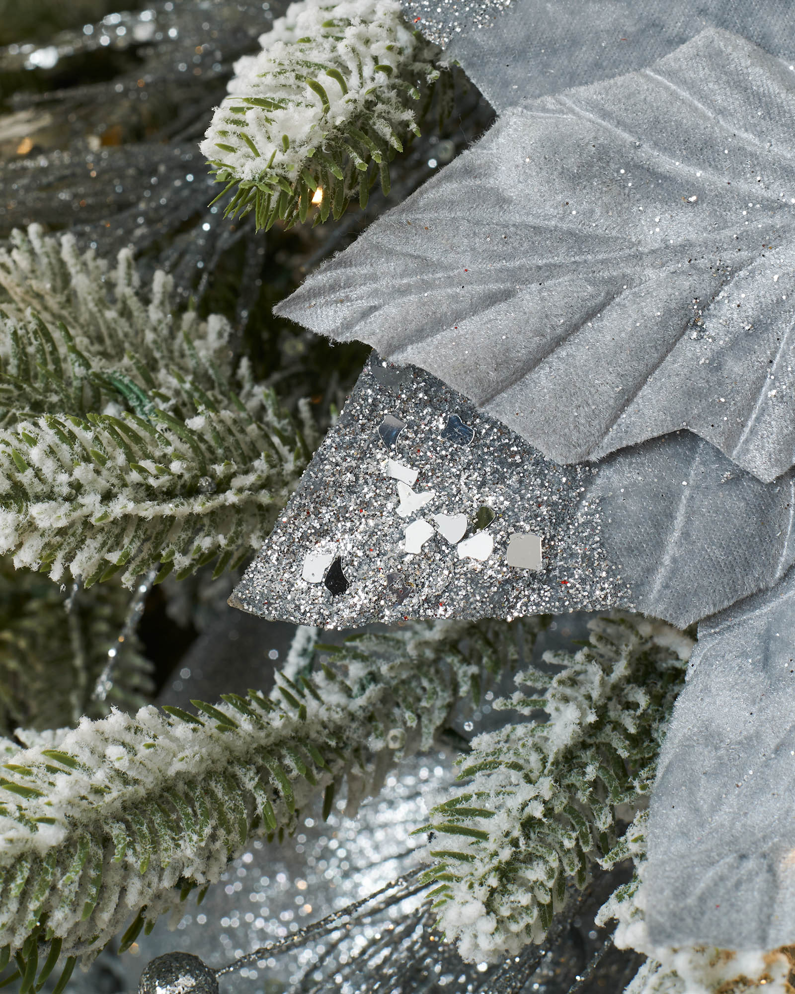 Detail of a silver artificial poinsettia petal with glitter and reflective sequin-style decoration.