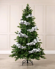 Silver bauble cluster arch styled around a green Christmas tree with shiny, matt and glitter baubles.