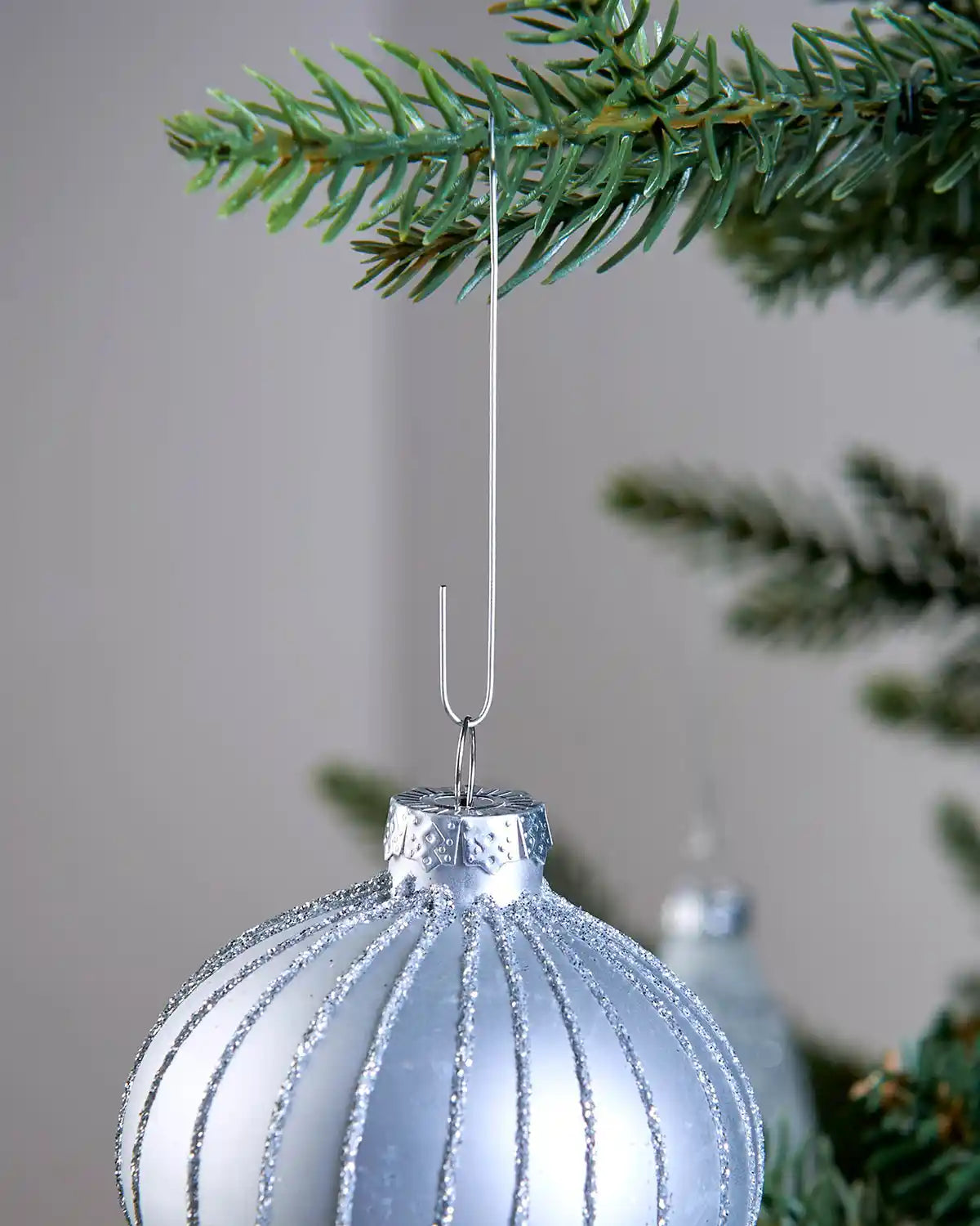 Silver bauble ornament hook hanging a bauble on a Christmas tree
