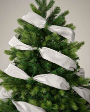 Silver velvet ribbon wrapped around a Christmas tree as a festive decoration.