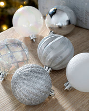 Close-up of silver and white 6cm baubles with glitter, pearl, mirrored and ribbed finishes