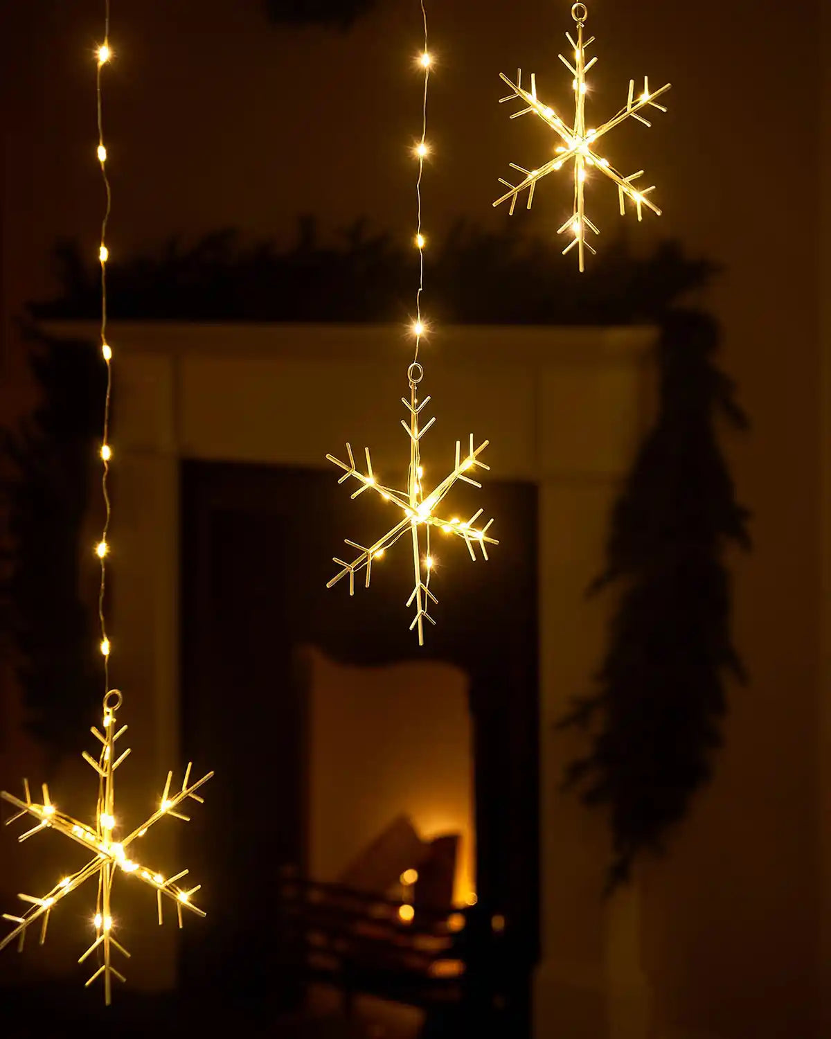 Detailed view of glowing warm white LED snowflake decoration on curtain lights