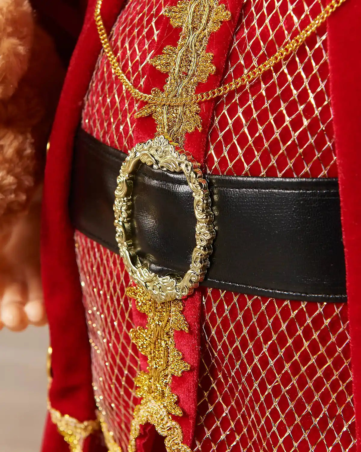 Close-up of the Santa figurine red outfit with gold trim and black belt