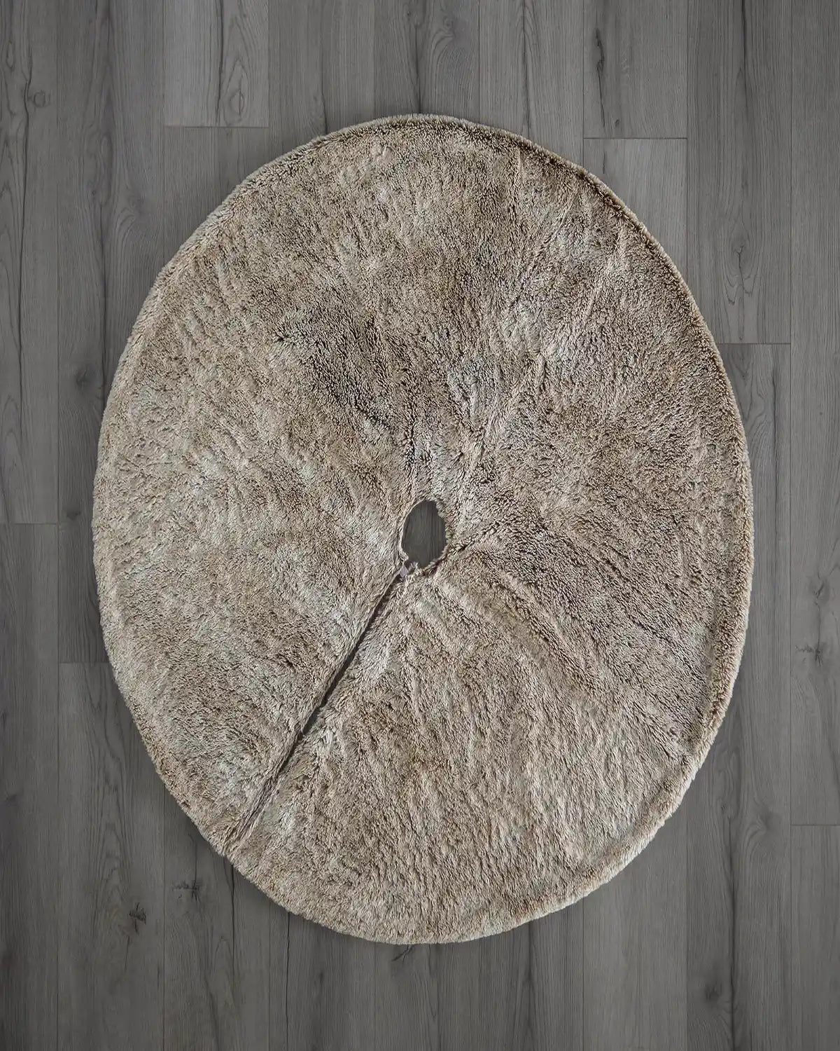 Top view of two-tone brown faux fur Christmas tree skirt on wooden floor