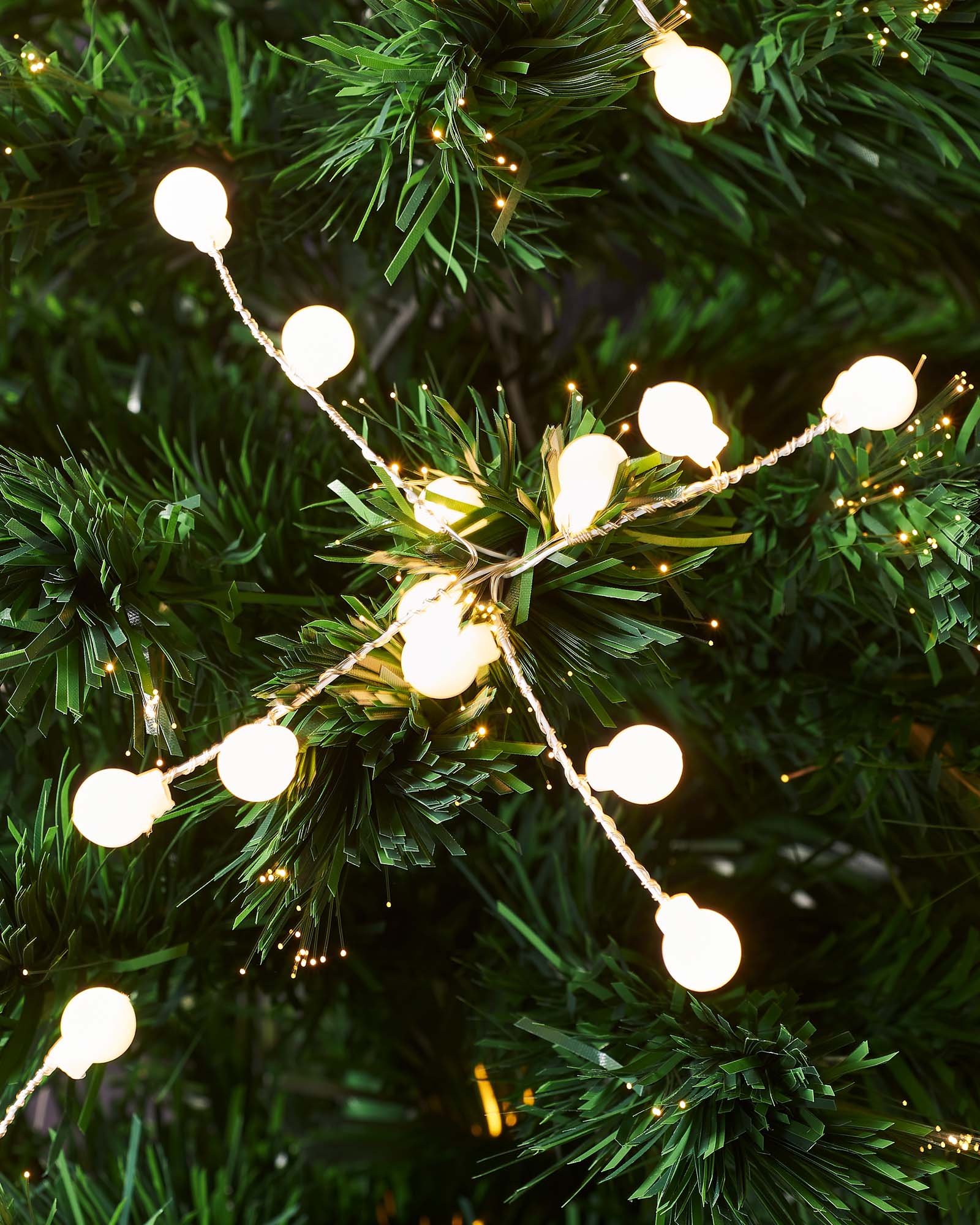 Close-up of warm white LED berry lights and fibre optic tips on the tree