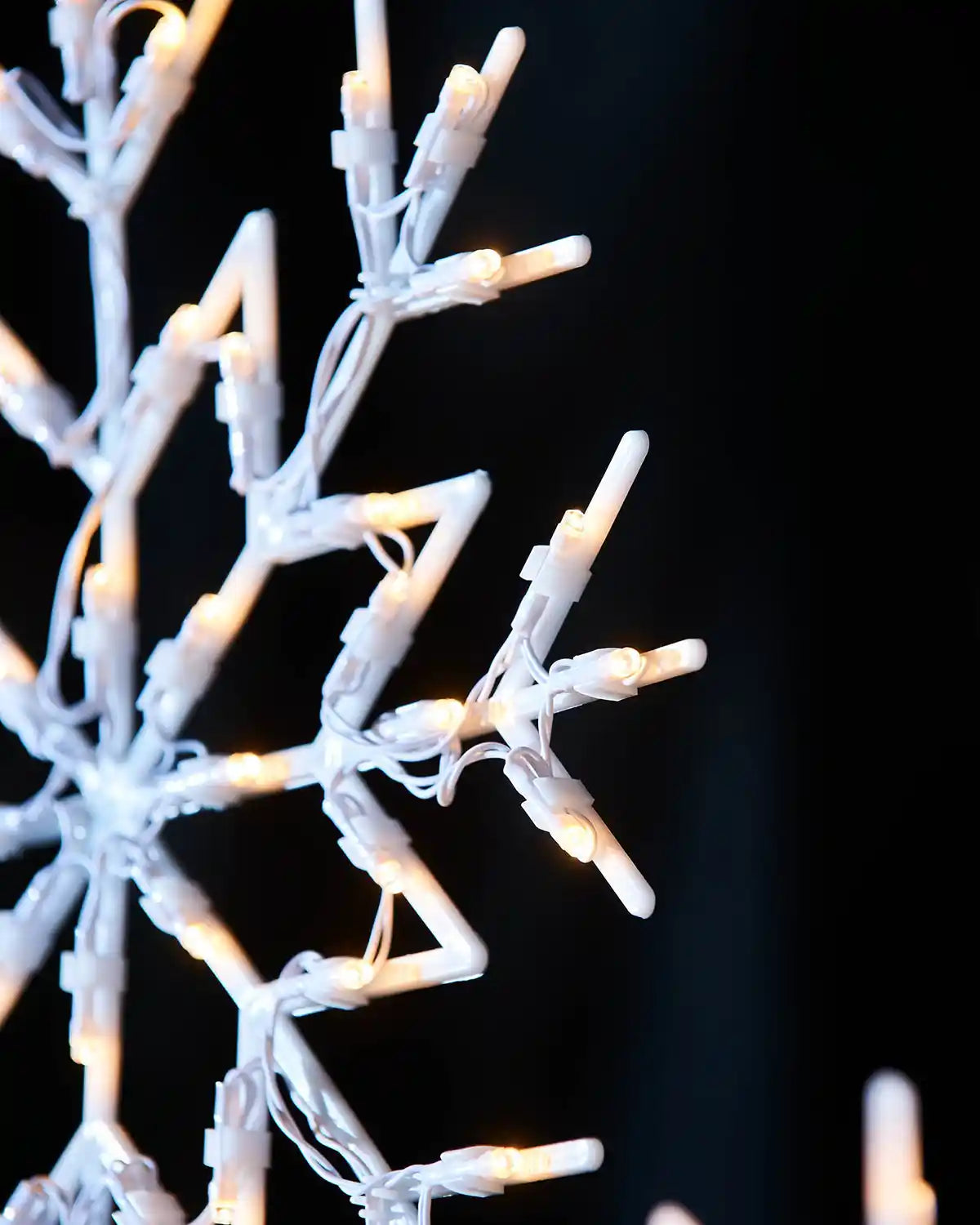Close-up of warm white LED lights on a snowflake silhouette decoration