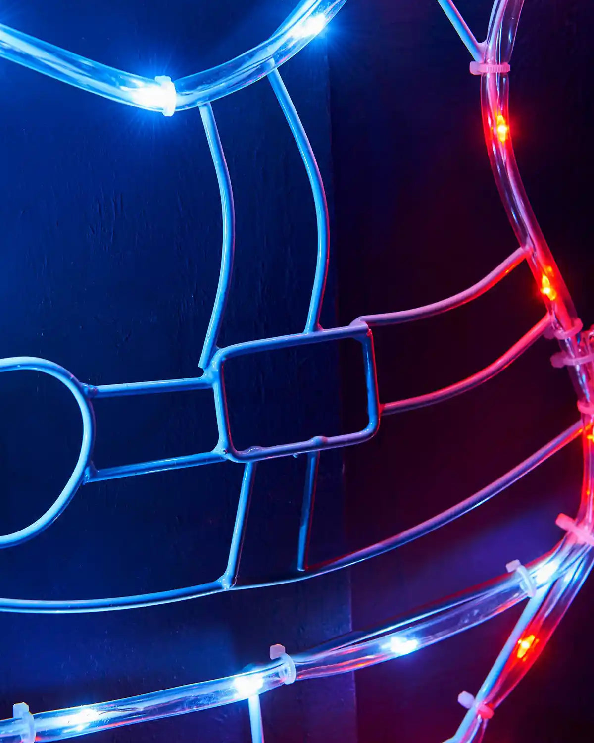 Close-up of the belt and red and white lights on the waving Santa silhouette