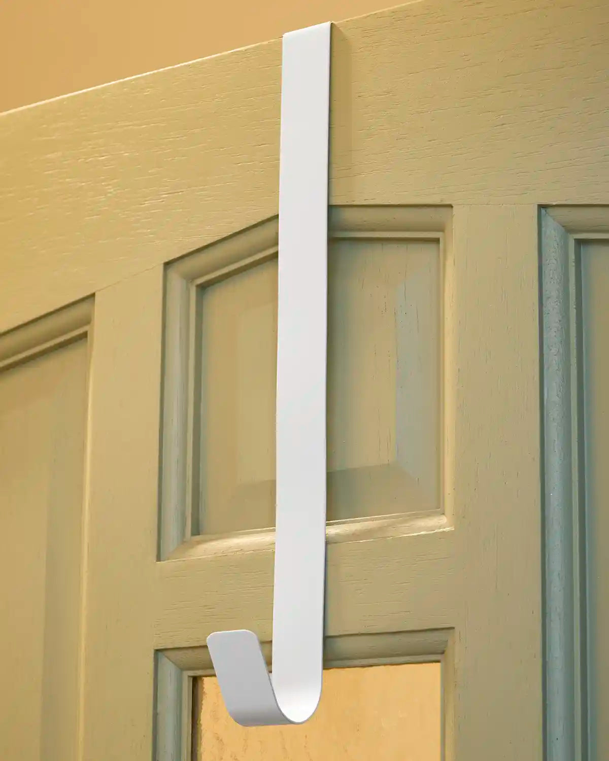 White 38 cm metal wreath hanger fitted over the top of a white door.