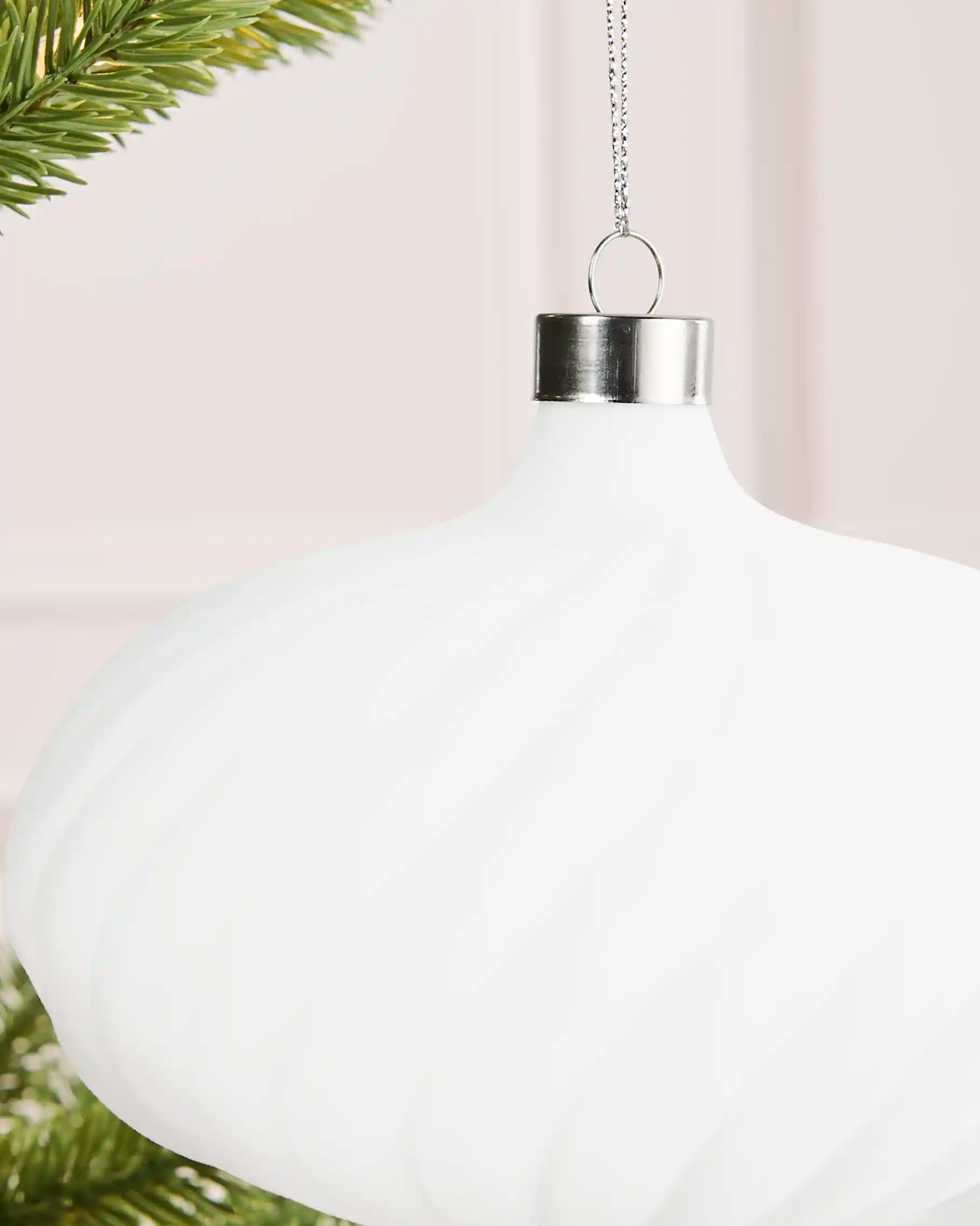 Close-up of a white 15 cm velvet spiral ribbed bauble showing the silver cap and top detail.