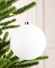15 cm white oversized velvet traditional bauble hanging from a Christmas tree with a smooth round finish.
