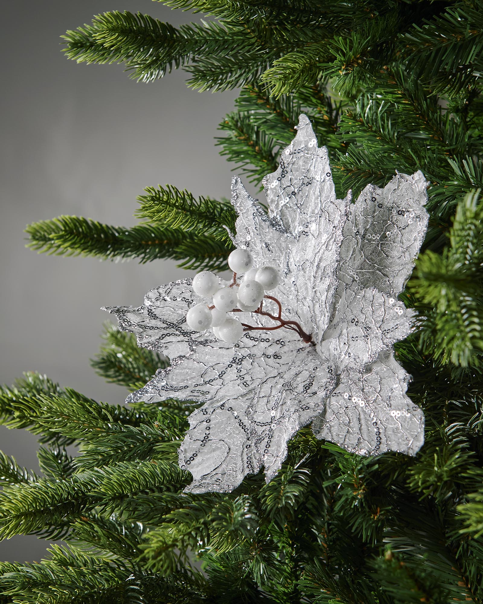 Close-up of white berries and silver sequin detail on poinsettia flower