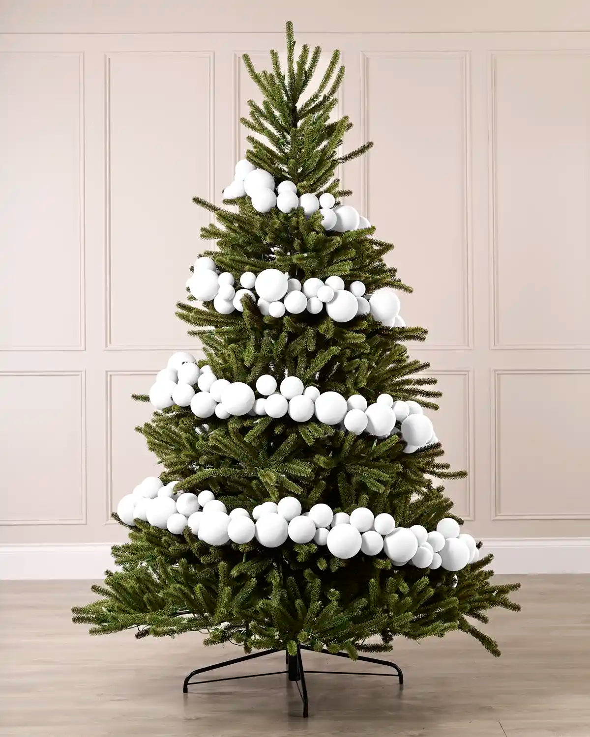 White velvet bauble garland wrapped around a green Christmas tree with mixed 5cm, 7cm and 10cm baubles.