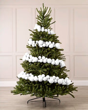 White velvet bauble garland wrapped around a green Christmas tree with mixed 5cm, 7cm and 10cm baubles.