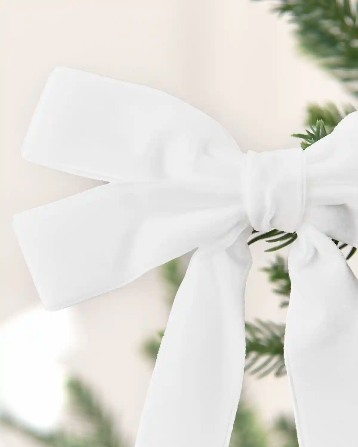 Close-up of a white velvet double bow showing layered loops, long tails and soft texture.