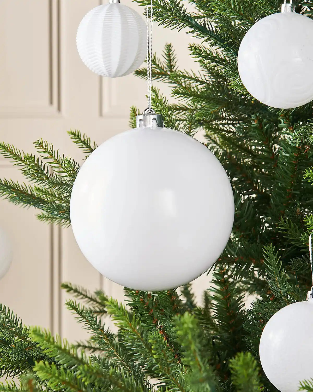 white gloss 15cm oversized bauble on a Christmas tree branch with 4 smaller white baubles on branch