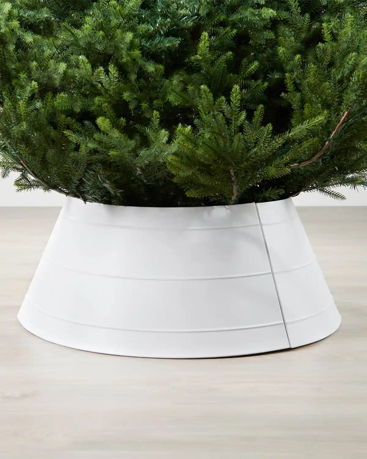 Close-up full image of white metal tree skirt on light wood flooring