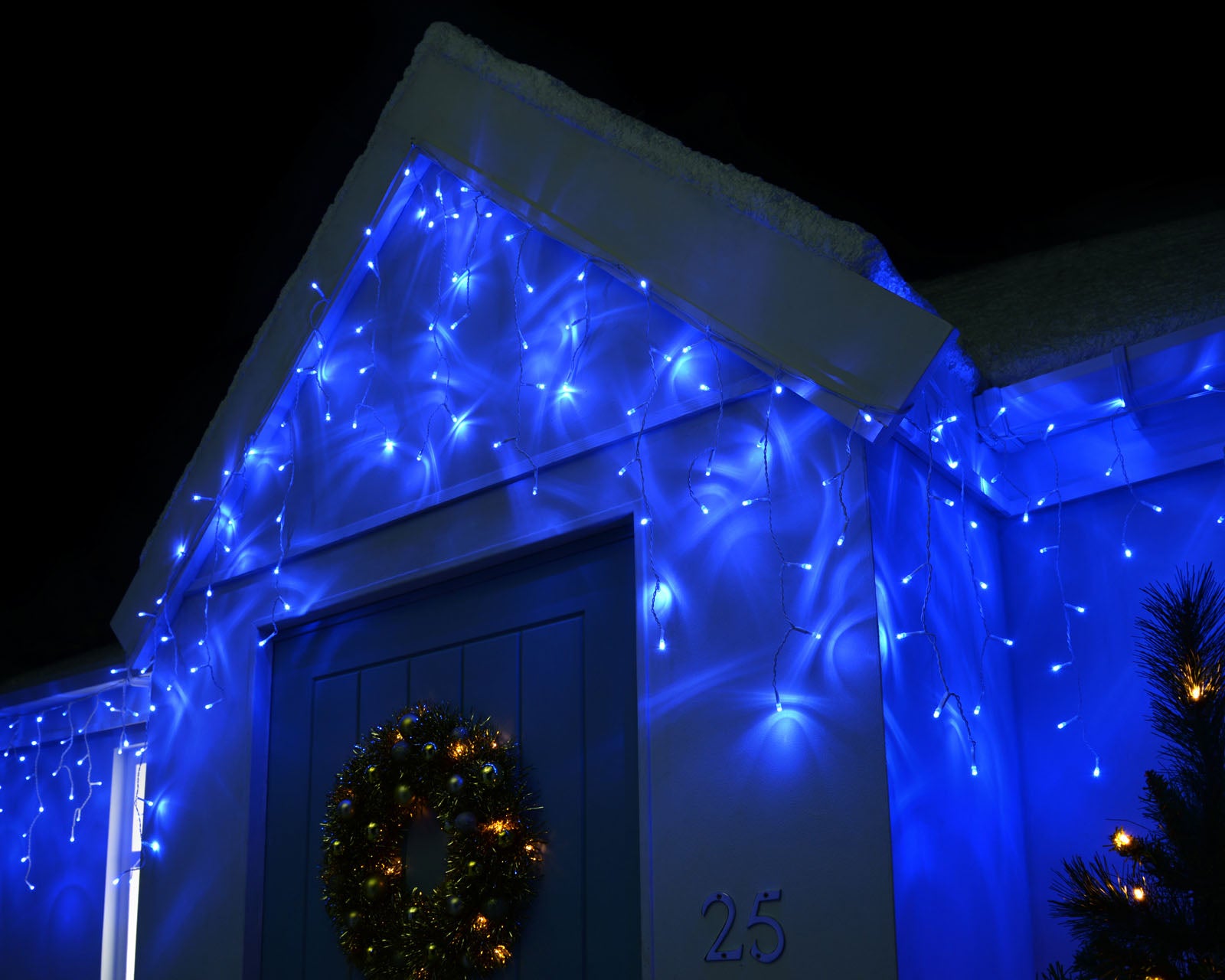 Blue LED icicle lights decorating the outside of a house at night