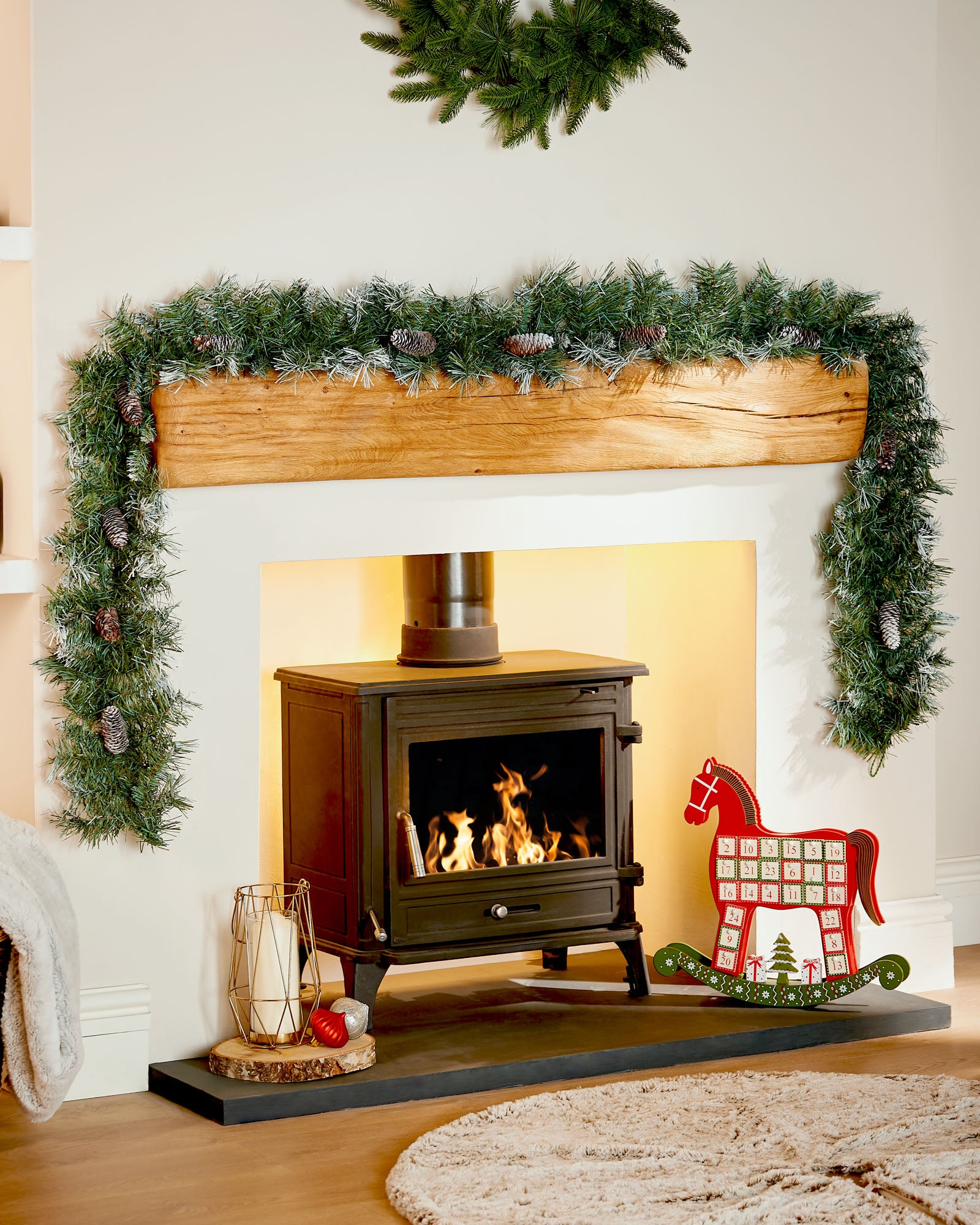 9 ft frosted blue spruce garland with pinecones displayed around a fireplace mantelpiece