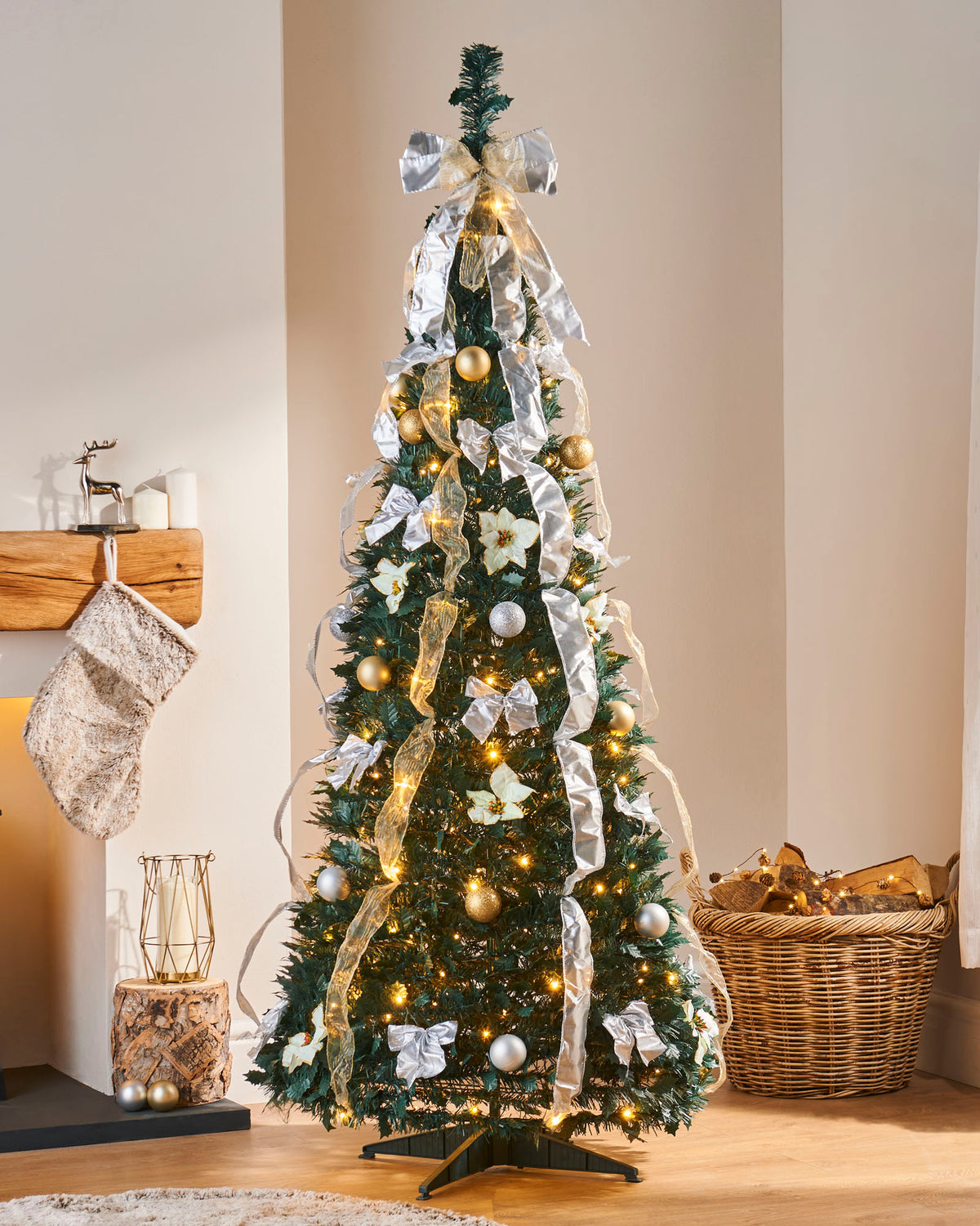 Pre-lit 6 ft decorated Holly Pop-Up Christmas tree with 150 warm white LEDs, champagne and silver baubles, poinsettias, and ribbons—easy setup, elegant festive centerpiece in a living room.