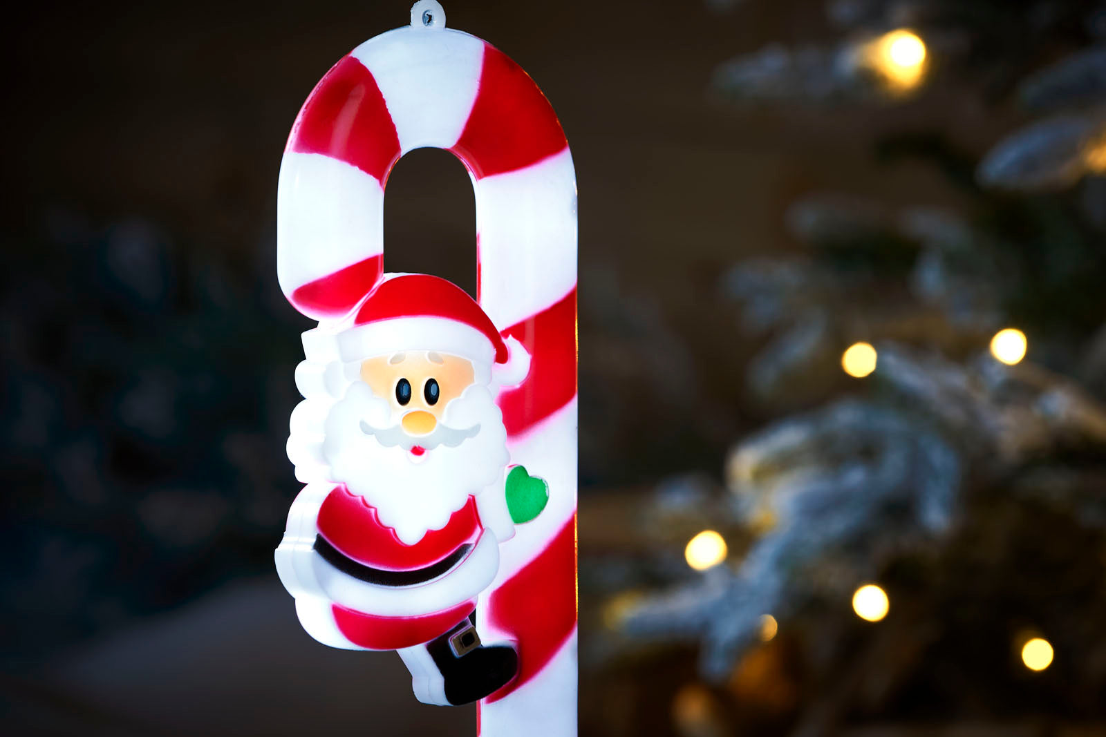 Close up of a red and white Santa Claus on a Candy cane garden stake
